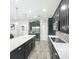 Stylish kitchen with stainless steel appliances, dark cabinets, tile backsplash, and a spacious island with counter seating at 1138 Fountain Coin Loop, Orlando, FL 32828