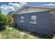 The home showcases a gray brick exterior with clean lines, accented by white trim and multiple windows at 119 Allen Ave, Winter Haven, FL 33880