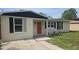 Charming single-story home featuring neutral paint, modern shutters, and a welcoming red front door at 1514 Crest Ave, Leesburg, FL 34748