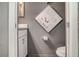 Powder room featuring grey walls, white fixtures, and elegant floral wall decor for a stylish touch at 1518 Louise Ave, Auburndale, FL 33823