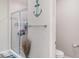 Modern bathroom featuring a glass-enclosed shower, decorative anchor accent, and fresh design, blending style and functionality at 1518 Louise Ave, Auburndale, FL 33823