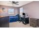 Bedroom with blue bed, desk, computer and ceiling fan at 1518 Louise Ave, Auburndale, FL 33823