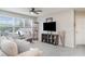 Bright living room features a ceiling fan, large windows, and gray carpet flooring at 1518 Louise Ave, Auburndale, FL 33823
