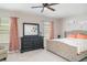 Bright main bedroom showcasing a tufted headboard, neutral palette, and a comfortable seating area by the window at 1518 Louise Ave, Auburndale, FL 33823