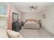Bright main bedroom showcasing a tufted headboard, neutral palette, and a comfortable seating area by the window at 1518 Louise Ave, Auburndale, FL 33823