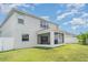 Exterior rear view of home featuring the screened porch, lawn, and white privacy fence at 1518 Louise Ave, Auburndale, FL 33823