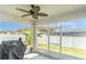 Screened porch with an outdoor ceiling fan, privacy fence, and a grill at 1518 Louise Ave, Auburndale, FL 33823