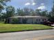 Exterior view of a single-story home with a green lawn and a red pickup truck in the driveway on a sunny day at 550 W Oak Dr, Lakeland, FL 33803
