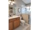 Neutral bathroom featuring wood cabinet, white marble top, framed art, and glass shower at 2509 Montecito Ave, Eustis, FL 32726