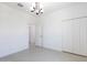 Bright bedroom featuring tiled flooring, a modern chandelier, and double door closet for ample storage space at 198 Gypsy Palace Ln, Daytona Beach, FL 32124