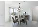 Dining room with a round glass table, gray chairs, and a window with white curtains at 198 Gypsy Palace Ln, Daytona Beach, FL 32124