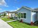 Charming single-story home featuring light blue siding, manicured lawn, and a covered walkway to the side entry at 198 Gypsy Palace Ln, Daytona Beach, FL 32124