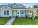Charming blue home with a welcoming front porch, lush landscaping, and a gray brick walkway at 198 Gypsy Palace Ln, Daytona Beach, FL 32124