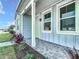 Covered front porch with brick flooring, white columns, and tasteful landscaping along the walkway at 198 Gypsy Palace Ln, Daytona Beach, FL 32124