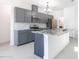Well-appointed kitchen with grey cabinetry, granite countertops, stainless appliances, and an island with bar seating at 198 Gypsy Palace Ln, Daytona Beach, FL 32124