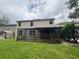 Backyard view featuring a screened-in patio and a well-maintained lawn at 606 Carrigan Woods Trl, Oviedo, FL 32765