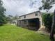 Backyard view featuring a screened-in patio and a well-maintained lawn at 606 Carrigan Woods Trl, Oviedo, FL 32765