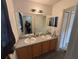 Bathroom featuring double sinks, mirror and vanity, with a neutral color palette at 606 Carrigan Woods Trl, Oviedo, FL 32765