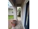 View of a covered entrance with a potted plant and view to the landscaped side yard at 606 Carrigan Woods Trl, Oviedo, FL 32765