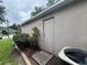 Exterior of a house with an external door, landscaping, and visible AC unit at 606 Carrigan Woods Trl, Oviedo, FL 32765