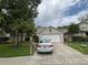 Charming two-story home featuring a two-car garage, well-maintained lawn, and mature shade tree at 606 Carrigan Woods Trl, Oviedo, FL 32765