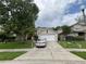 Charming two-story home featuring a two-car garage, well-maintained lawn, and mature shade tree at 606 Carrigan Woods Trl, Oviedo, FL 32765