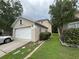 Exterior view showcasing the side of the house and the two-car garage with a driveway at 606 Carrigan Woods Trl, Oviedo, FL 32765