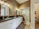 Stylish bathroom featuring double sink vanity with granite countertop and a modern glass shower at 10222 Rockridge Rd, Lakeland, FL 33810