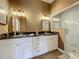 Modern bathroom with double sinks, granite countertops and glass shower with marble tile at 10222 Rockridge Rd, Lakeland, FL 33810