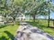 Long driveway leading to a charming home with mature trees and rustic accents at 10222 Rockridge Rd, Lakeland, FL 33810