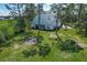 Wide view of a charming green-roofed home nestled among lush green trees and expansive grassy lawn at 10222 Rockridge Rd, Lakeland, FL 33810
