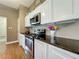 Well-lit kitchen features stainless steel appliances, modern black countertop, and beautiful white cabinetry at 10222 Rockridge Rd, Lakeland, FL 33810