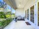 Charming screened porch with white wicker furniture overlooking lush greenery and a golf course at 10222 Rockridge Rd, Lakeland, FL 33810