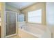 Bright bathroom featuring a tub, glass shower, and large window for ample natural light at 2925 Dayton Dr, Winter Haven, FL 33884