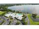 Aerial view showcasing the clubhouse and pool with a lake in the distance at 2925 Dayton Dr, Winter Haven, FL 33884