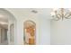 Dining area featuring arched doorways, a chandelier, and view of the kitchen featuring cabinetry and white appliances at 2925 Dayton Dr, Winter Haven, FL 33884