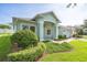 Beautiful home with light green exterior, brick-paved walkway, and lush landscaping, exuding a welcoming and well-maintained appearance at 2925 Dayton Dr, Winter Haven, FL 33884