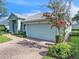 Garage exterior view with manicured landscaping, blooming tree, and light blue door providing a beautiful and welcoming curb appeal at 2925 Dayton Dr, Winter Haven, FL 33884
