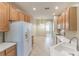Well-lit kitchen featuring ample cabinet space, a white refrigerator, and a large sink area at 2925 Dayton Dr, Winter Haven, FL 33884