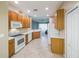 Bright kitchen with white appliances, wooden cabinets, and tile flooring for a clean aesthetic at 2925 Dayton Dr, Winter Haven, FL 33884