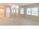 Bright, carpeted living room featuring large windows, high ceilings, and arched doorways creating an open and airy atmosphere at 2925 Dayton Dr, Winter Haven, FL 33884