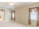 Spacious main bedroom with large windows, neutral carpet, and an arched doorway to ensuite bathroom at 2925 Dayton Dr, Winter Haven, FL 33884