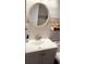 Stylish bathroom with a modern vanity, round mirror, and decorative tile accents at 4733 Club Cir, Lakeshore, FL 33854