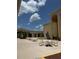 Inviting courtyard featuring tables, chairs, umbrellas, a tranquil fountain, and well-manicured landscaping at 4733 Club Cir, Lakeshore, FL 33854