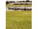 Picturesque view of the waterfront with a long grass shore and dock at 4733 Club Cir, Lakeshore, FL 33854