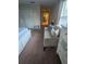 Bedroom view with plush carpet, comfortable settee, and view into hallway with ensuite at 8923 Cuban Palm Rd, Kissimmee, FL 34747