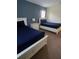 Bedroom showcasing two white twin beds with blue bedding and coordinating nightstand at 8923 Cuban Palm Rd, Kissimmee, FL 34747