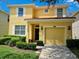Charming two-story yellow home featuring a red tile roof, and a well-manicured lawn at 8923 Cuban Palm Rd, Kissimmee, FL 34747