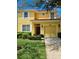 Charming two-story yellow home featuring a red tile roof, and a well-manicured lawn at 8923 Cuban Palm Rd, Kissimmee, FL 34747