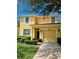 Charming two-story yellow home featuring a red tile roof, and a well-manicured lawn at 8923 Cuban Palm Rd, Kissimmee, FL 34747